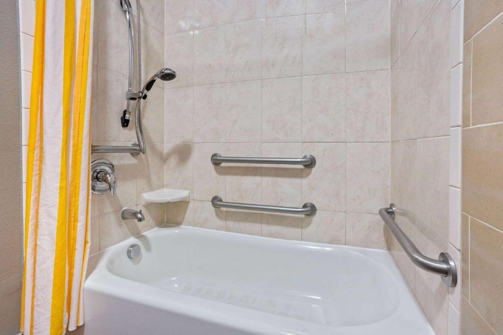 a bathroom with a white tub in a room at La Quinta by Wyndham Houston IAH Bush Intl Airport E in Humble