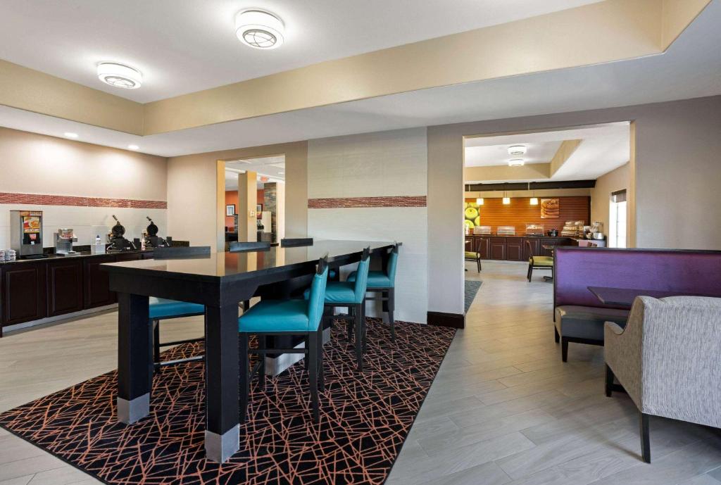 a dining room and lobby with a table and chairs at La Quinta by Wyndham Houston IAH Bush Intl Airport E in Humble