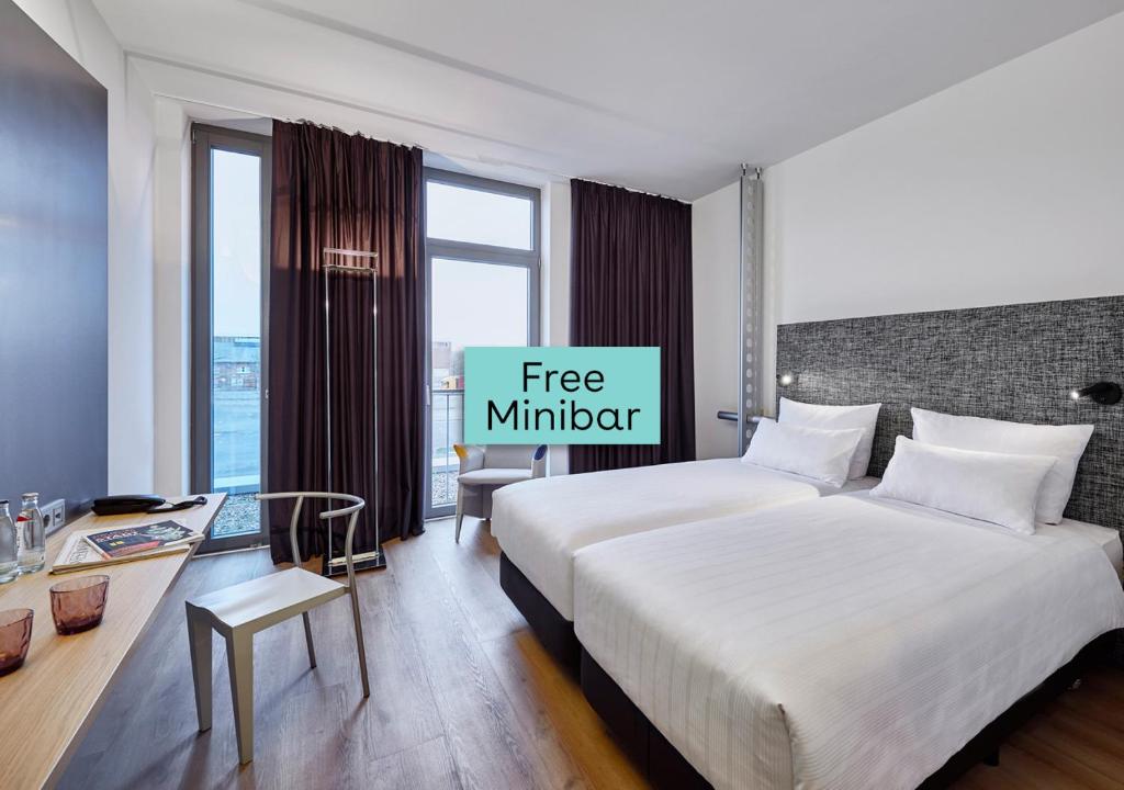 two beds in a hotel room with a free multiplier sign at INNSiDE by Meliá Bremen in Bremen