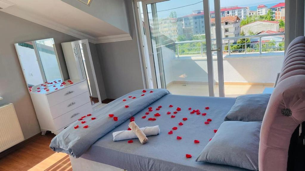 a bedroom with a bed with red roses on it at Bagdad MOTEL in Akçatepe