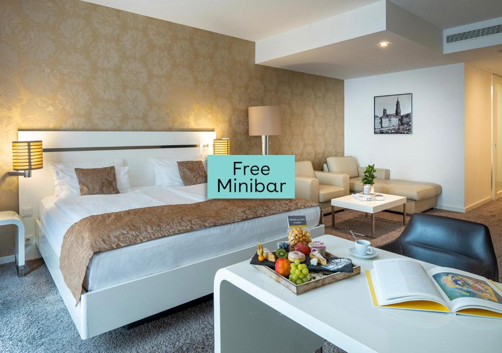a hotel room with a bed and a desk with a free miter at INNSiDE by Meliá Dresden in Dresden