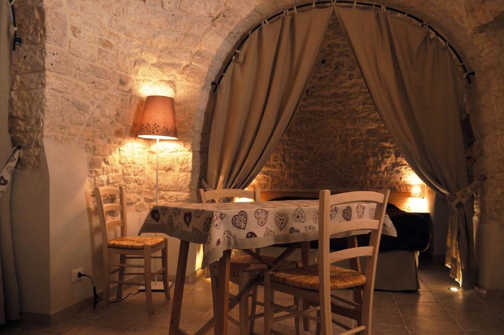 アルベロベッロにあるCasa Vacanze Piazzetta XI Febbraioの石壁の部屋(テーブル、椅子付)