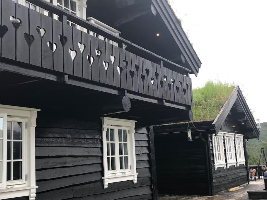 un edificio de madera con balcón en la parte superior. en Nydelig hytte på Kvamskogen, nær Hardangerfjorden en Kvam