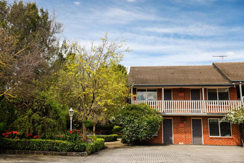 a brick house with a balcony on the side of it at Elizabethan Lodge in Melbourne