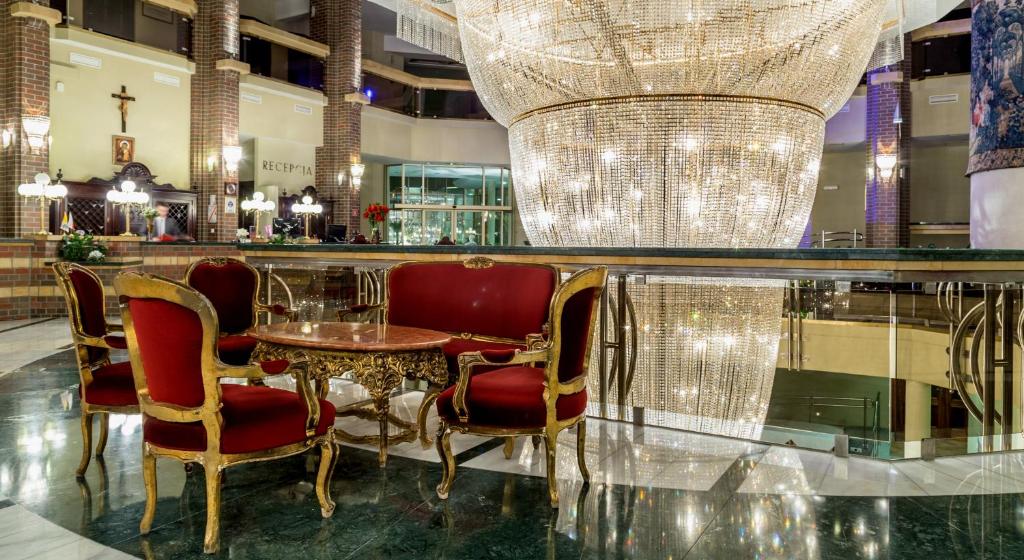 um restaurante com uma mesa e cadeiras e um lustre em Hotel im. Jana Pawła II em Breslávia