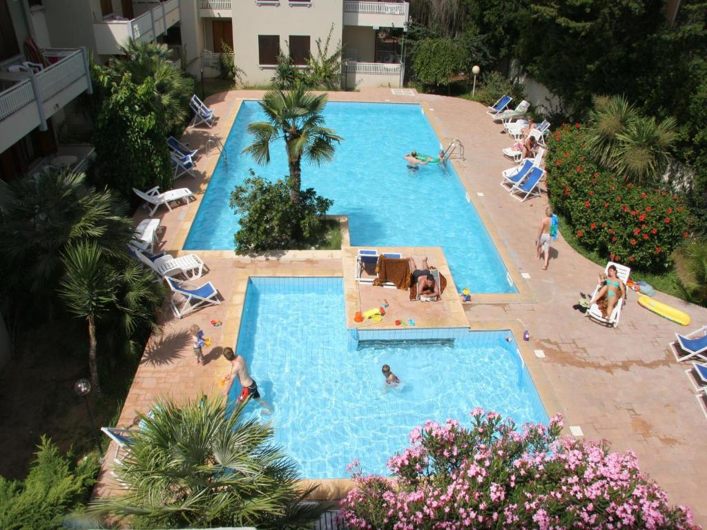 an overhead view of a large swimming pool with people in it at Residence Eucalipti in Alghero
