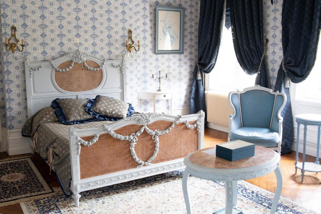 a bedroom with a bed and a chair at Domaine de Bertheauville in Paluel