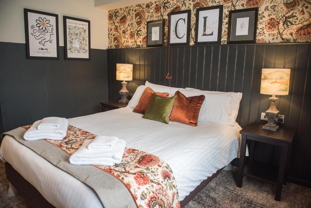 1 dormitorio con 1 cama grande y 2 toallas. en Cat & Lion Country Pub and Hotel en Warrington