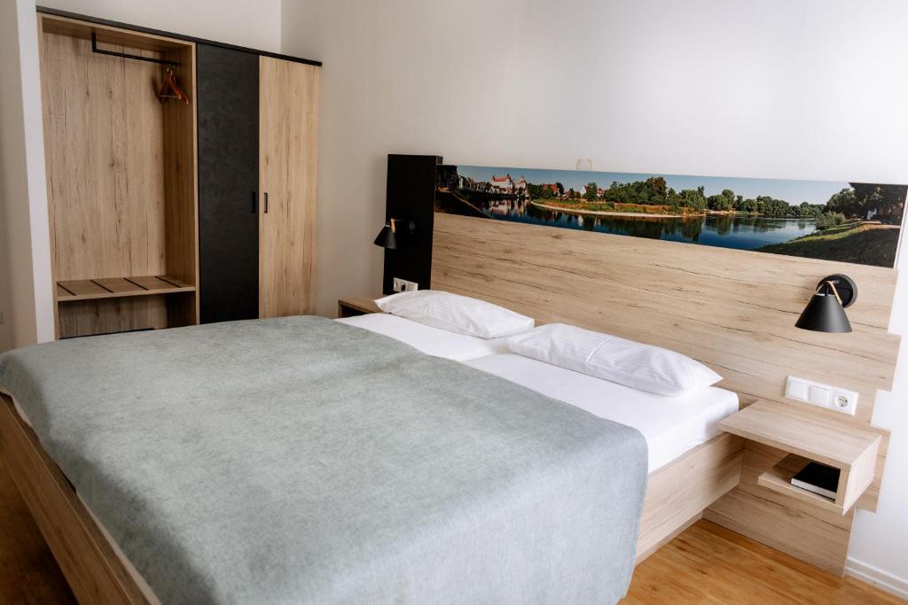 a bedroom with a large bed with a large window at Hotel am Fluss in Neuburg an der Donau