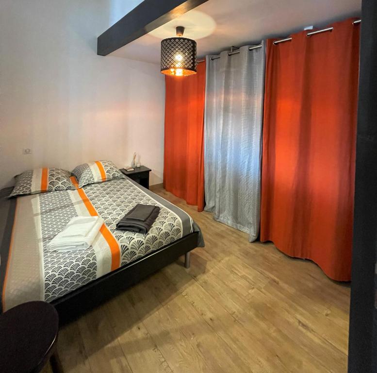 - une chambre avec un lit et des rideaux rouges dans l'établissement T2 de 40 m2 - facile d’accès, lumineux et au calme, à Saint-Genest-Lerpt