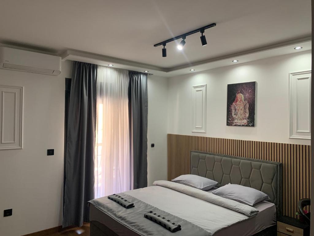 a bedroom with a large bed with remote controls on it at AD luxury in Podgorica
