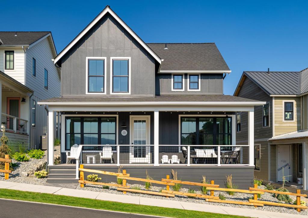 a gray house with a porch with white chairs at Live Laugh Chelan #136 in Chelan