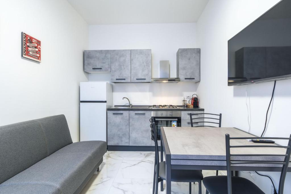 a kitchen with a couch and a table in a room at Easylife - Appartamento elegante moderno e accogliente - la tua oasi in città in Milan