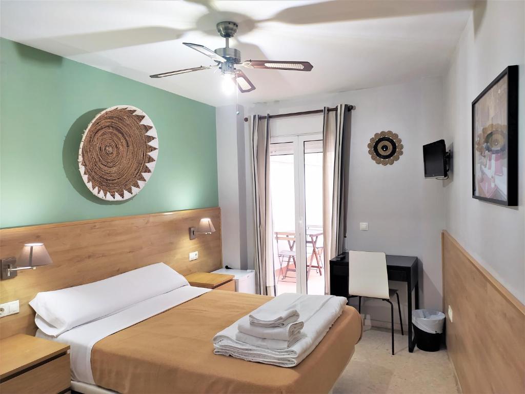 een slaapkamer met een bed en een plafondventilator bij Habitaciones Barra89 in Valencia