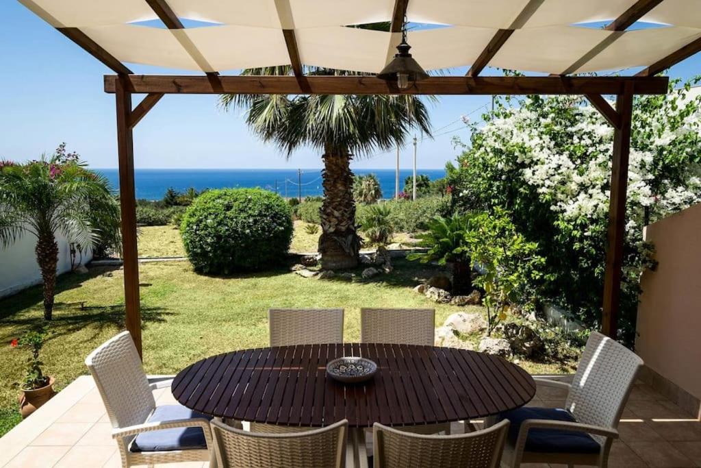 einen Tisch und Stühle auf einer Terrasse mit Meerblick in der Unterkunft Casa Grecale Macari in Macari