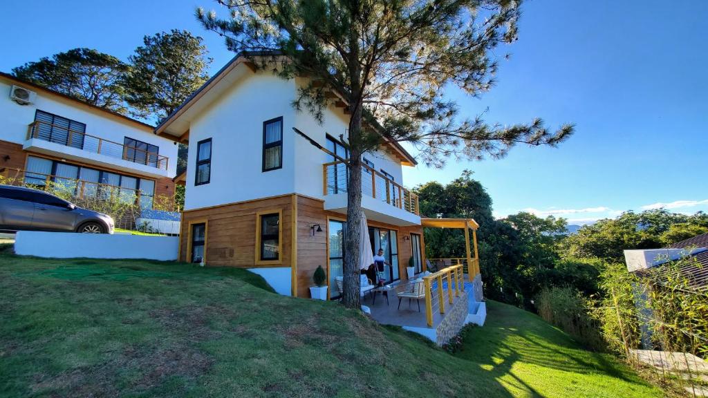 a house on a hill with a tree at Villa en la montaña in Jarabacoa