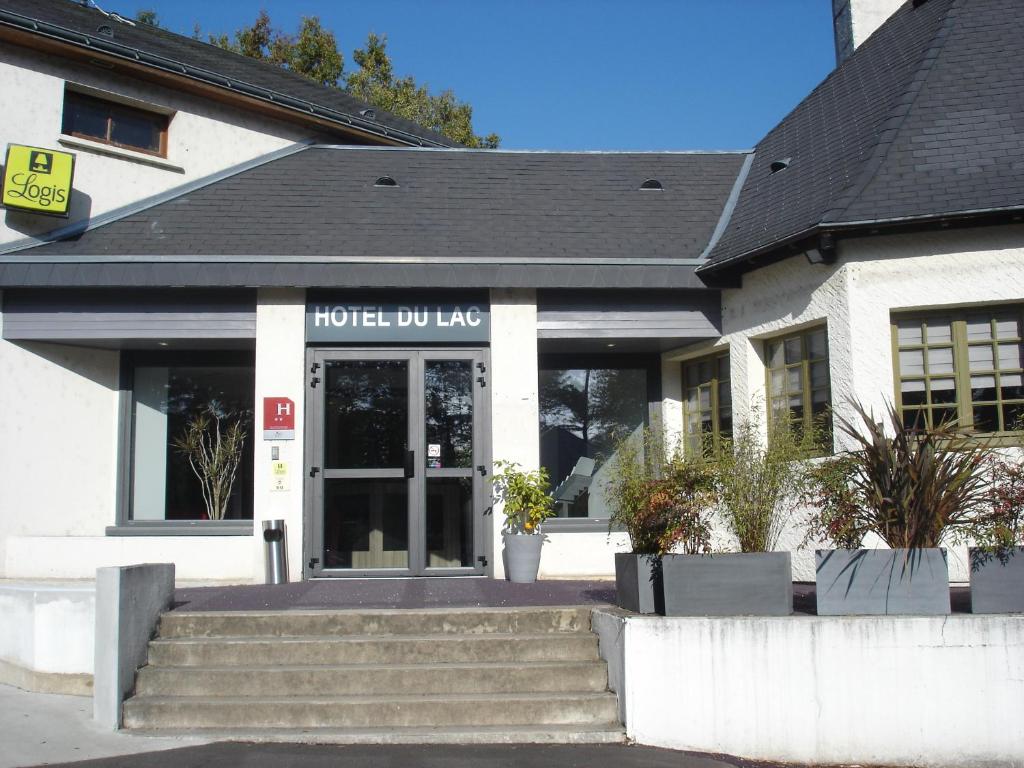 a hotel lobby with stairs in front of a building at Hotel-Restaurant Du Lac in Joue-les-Tours