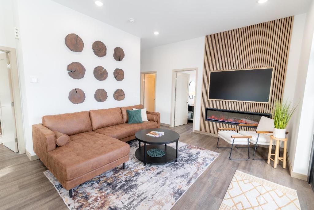 ein Wohnzimmer mit einem Sofa und einem Flachbild-TV in der Unterkunft Colony Suites in Palmer