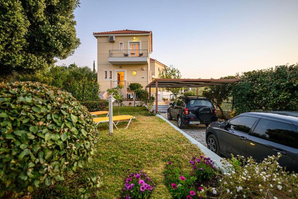 una casa con coches aparcados frente a un patio en Ridomo Sea View, en Akrogiali