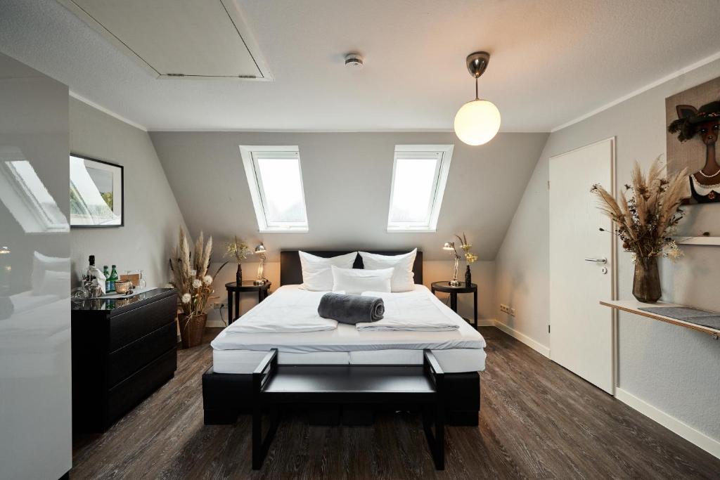 a bedroom with a large bed with white sheets at Boutique Hotel am Markt in Melle