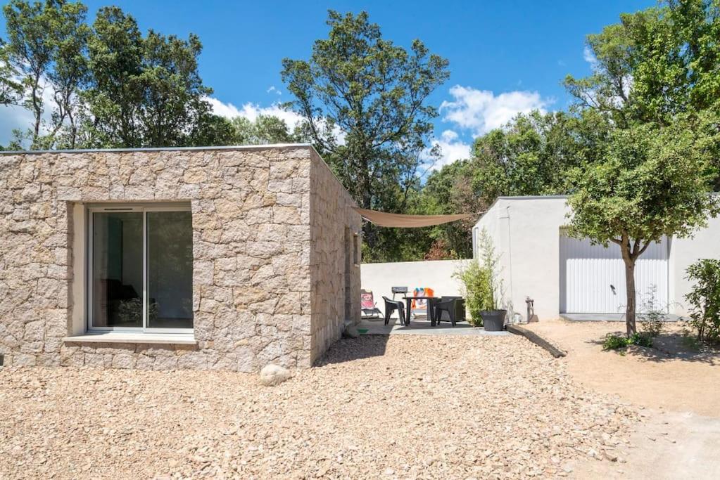 Cette maison en pierre dispose d'une grande fenêtre et d'une terrasse. dans l'établissement Studio en pierre U Pinu, 2 personnes, Muratello, 6 Kms de Porto Vecchio, à Porto-Vecchio