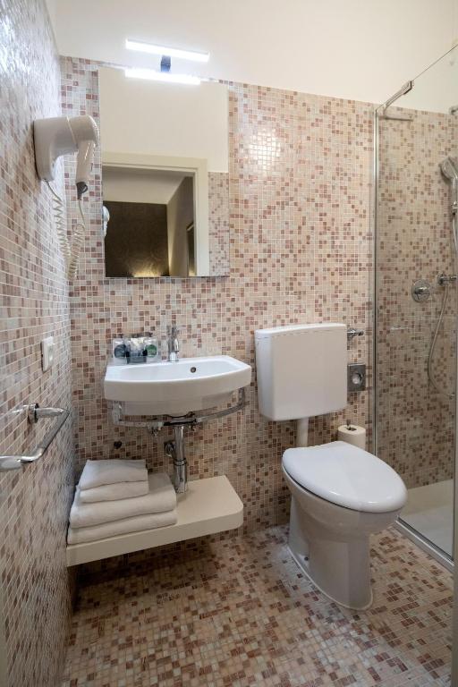 a bathroom with a toilet and a sink and a shower at Alle Guglie Boutique Hotel in Venice
