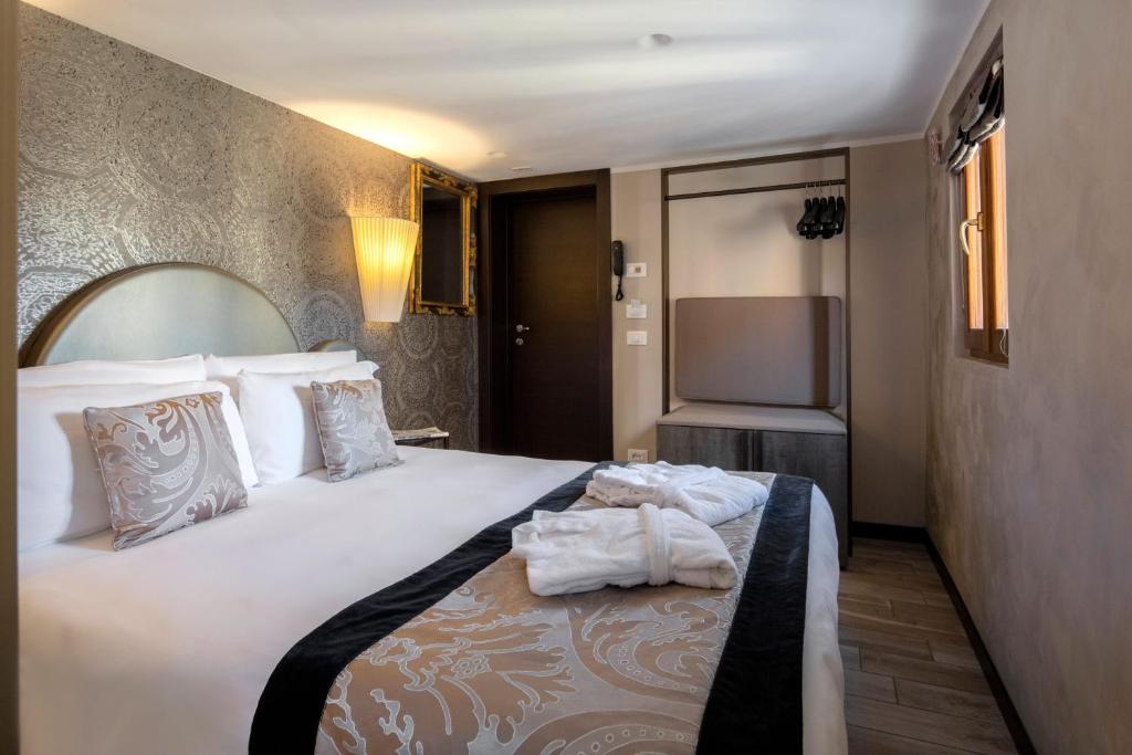 a hotel room with a large bed with towels on it at Alle Guglie Boutique Hotel in Venice