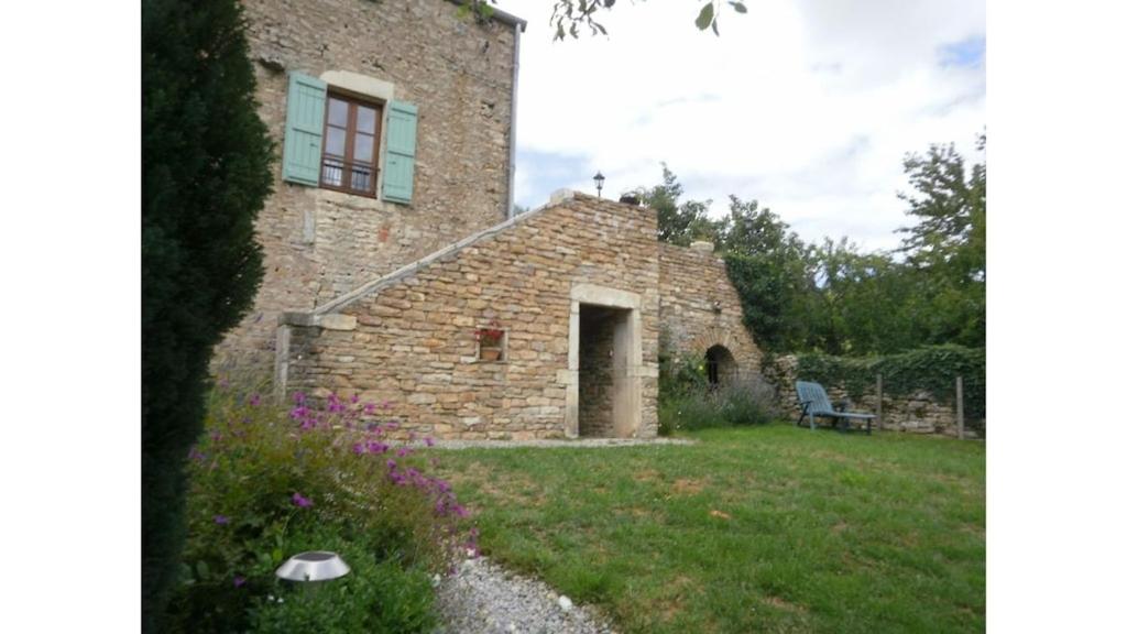 un edificio de ladrillo con una puerta en el patio en Maison rénovée sur domaine viticole Renovated old house on wine estate en Chassey-le-Camp