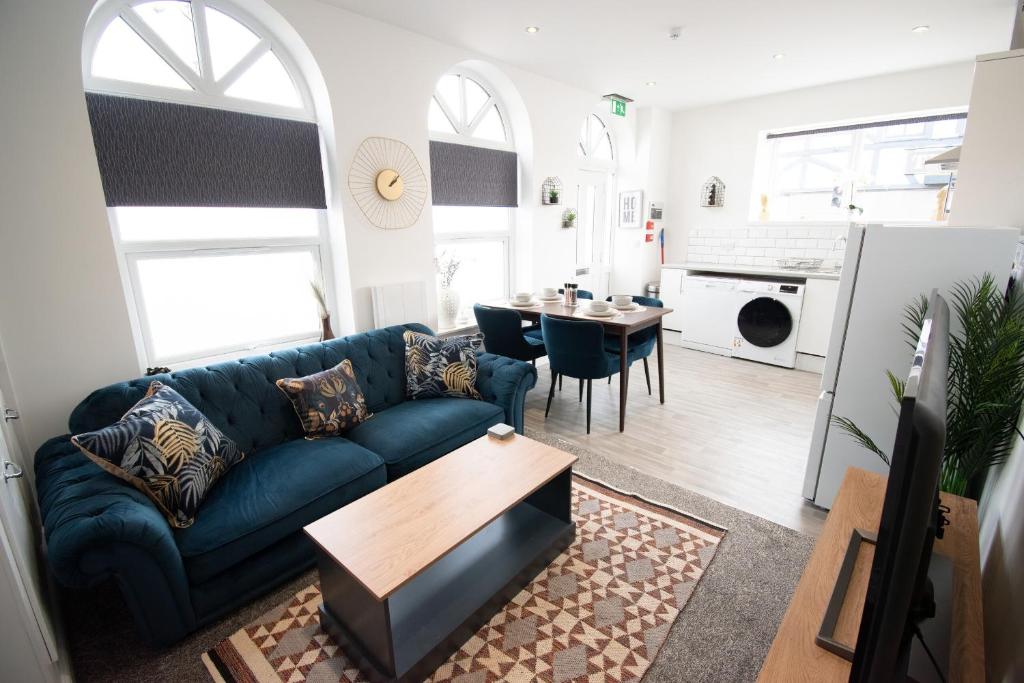 - un salon avec un canapé bleu et une table dans l'établissement Ideal Lodgings in Walkden, 