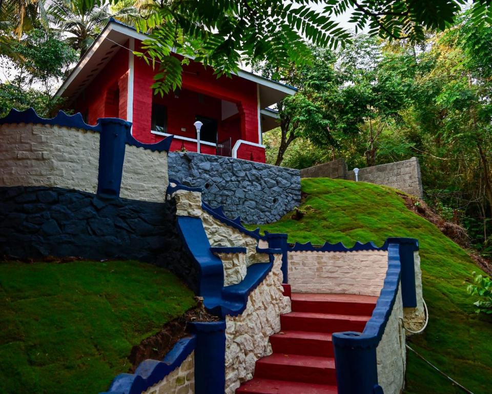 una escalera que conduce a una casa con una casa roja en VIP GARDEN RESORT, en Varkala