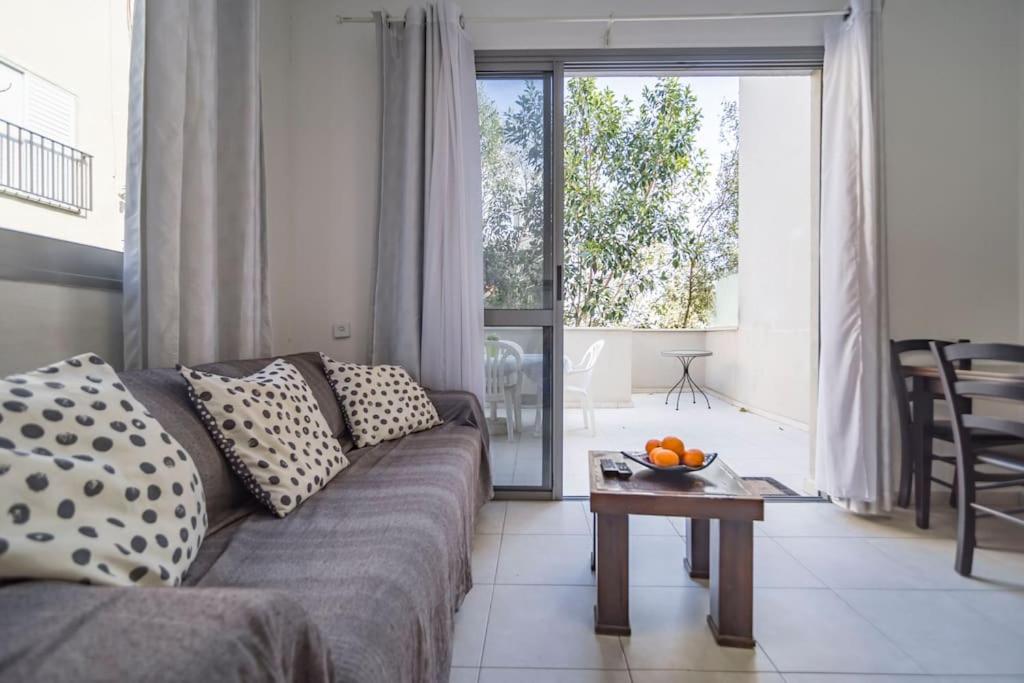 sala de estar con sofá y mesa en Lovely 2 rooms with big terrace en Tel Aviv