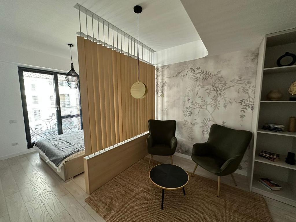 a living room with two chairs and a table at Urban Flats in Bucharest