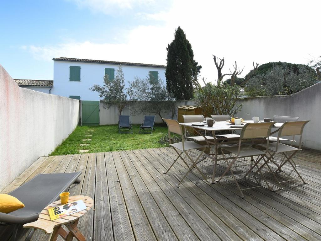 a patio with a table and chairs on a deck at Maison La Couarde-sur-Mer, 4 pièces, 6 personnes - FR-1-258-8 in La Couarde-sur-Mer
