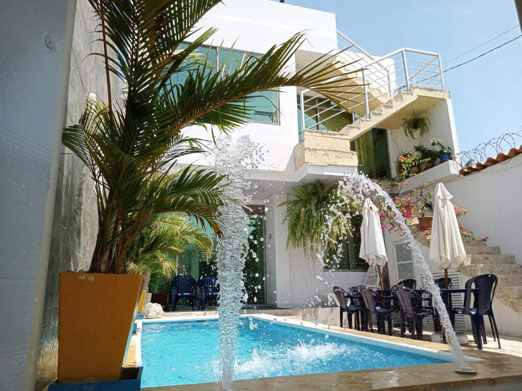 a swimming pool with a fountain in a house at Casa Sol Naciente in Cartagena de Indias