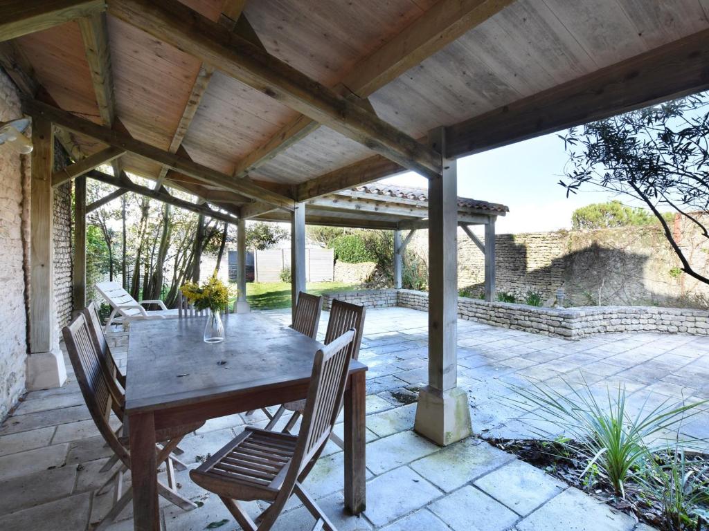 een houten tafel en stoelen op een patio bij Villa Saint-Clément-des-Baleines, 5 pièces, 8 personnes - FR-1-258-13 in Saint-Clément-des-Baleines