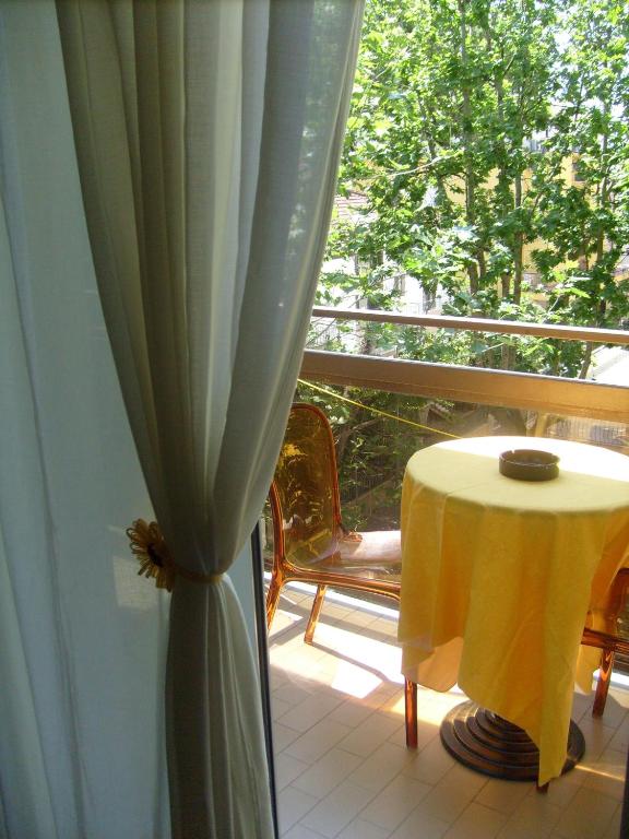 a room with a table and a window with a curtain at Hotel Tiziana in Rimini