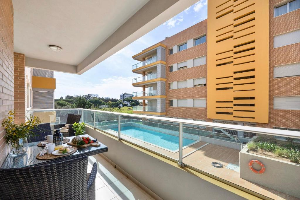 einen Balkon mit Pool auf einem Gebäude in der Unterkunft Gorgeous Apartment with Pool & 4 minutes to Beach in Quarteira