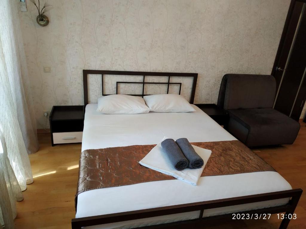 a bedroom with a bed with a pillow and a chair at Doba In Ua Peremoga Apartments in Dnipro