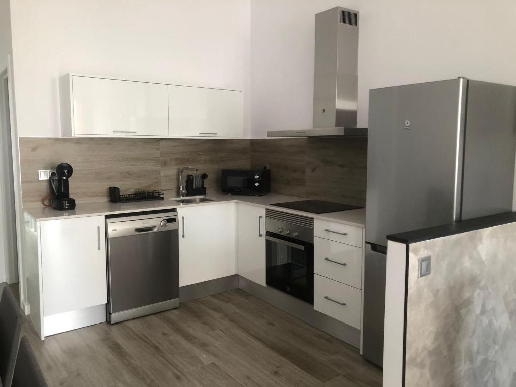 Hotel Urban Beach, a kitchen with white cabinets and a stainless steel refrigerator at Urban Beach in Valencia