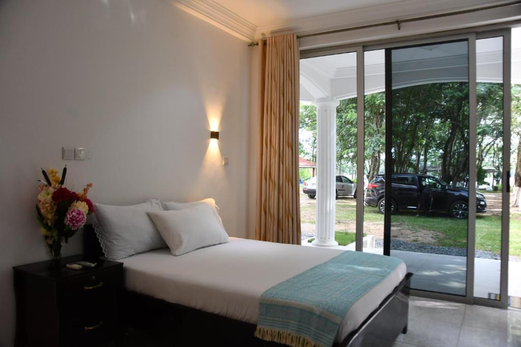 Schlafzimmer mit einem Bett und einer Glasschiebetür in der Unterkunft Raffin Royal Lodge 