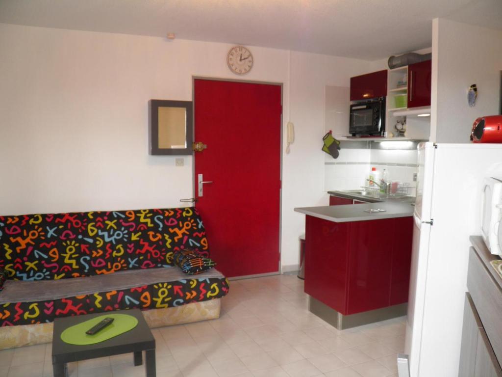 a living room with a couch and a red door at Appartement Sète, 2 pièces, 4 personnes - FR-1-338-13 in Sète