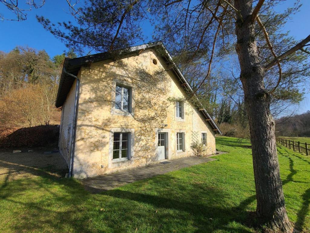 una casa de piedra en un campo con un árbol en Lovely holiday home in Orval with garden en Florenville