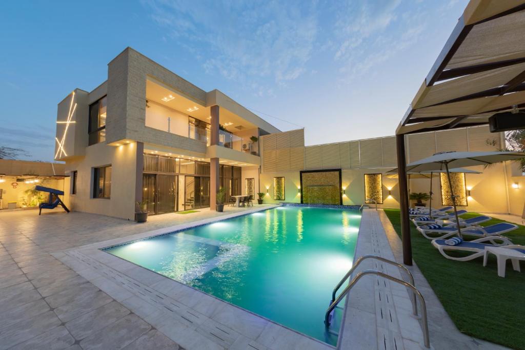 a swimming pool in front of a house at Adam's Luxury Villa DeadSea in Sowayma