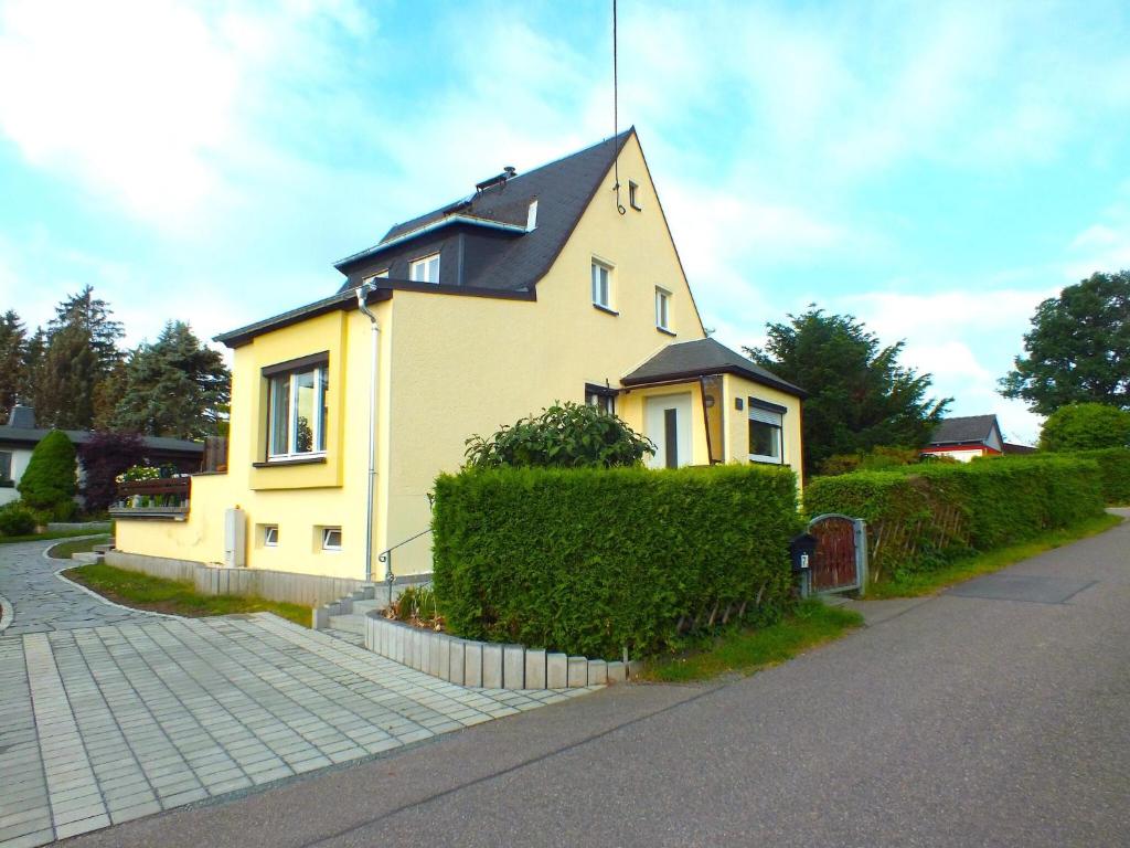 una casa amarilla sentada al lado de una calle en Inviting Holiday Home in Lichtenau with Garden, 