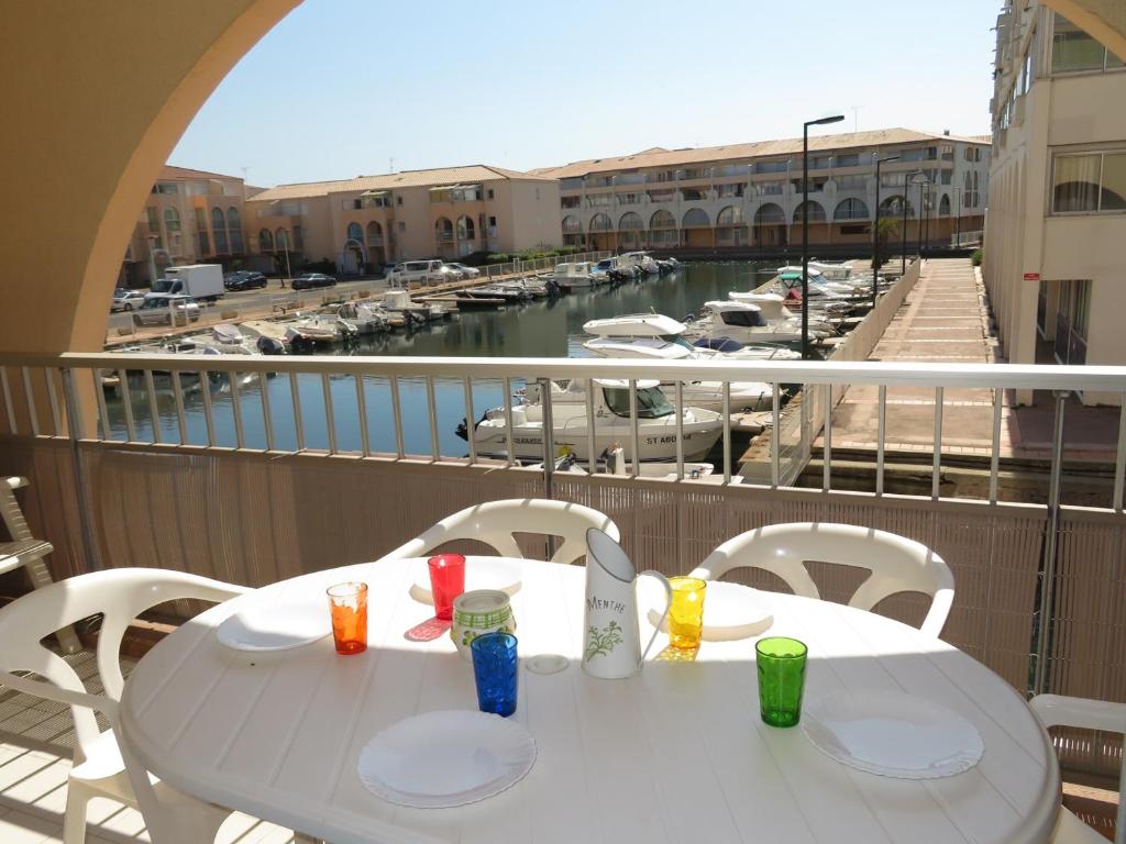 a white table and chairs on a balcony with a marina at Appartement Sète, 2 pièces, 4 personnes - FR-1-338-136 in Sète