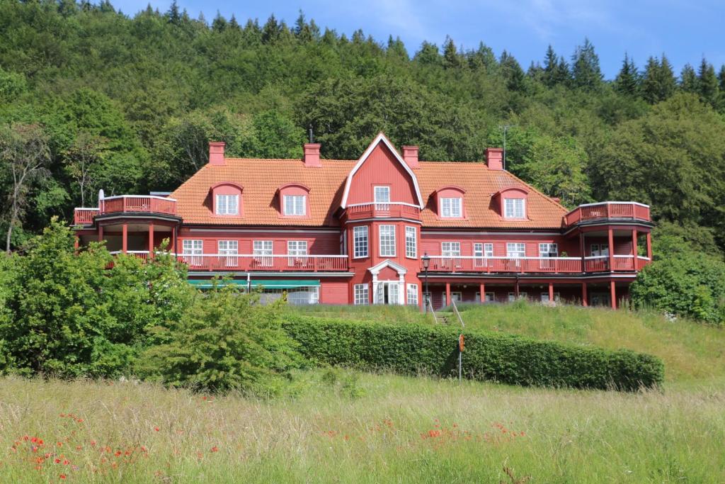 una gran casa roja en la cima de una colina en Ombergs Turisthotell en Ödeshög