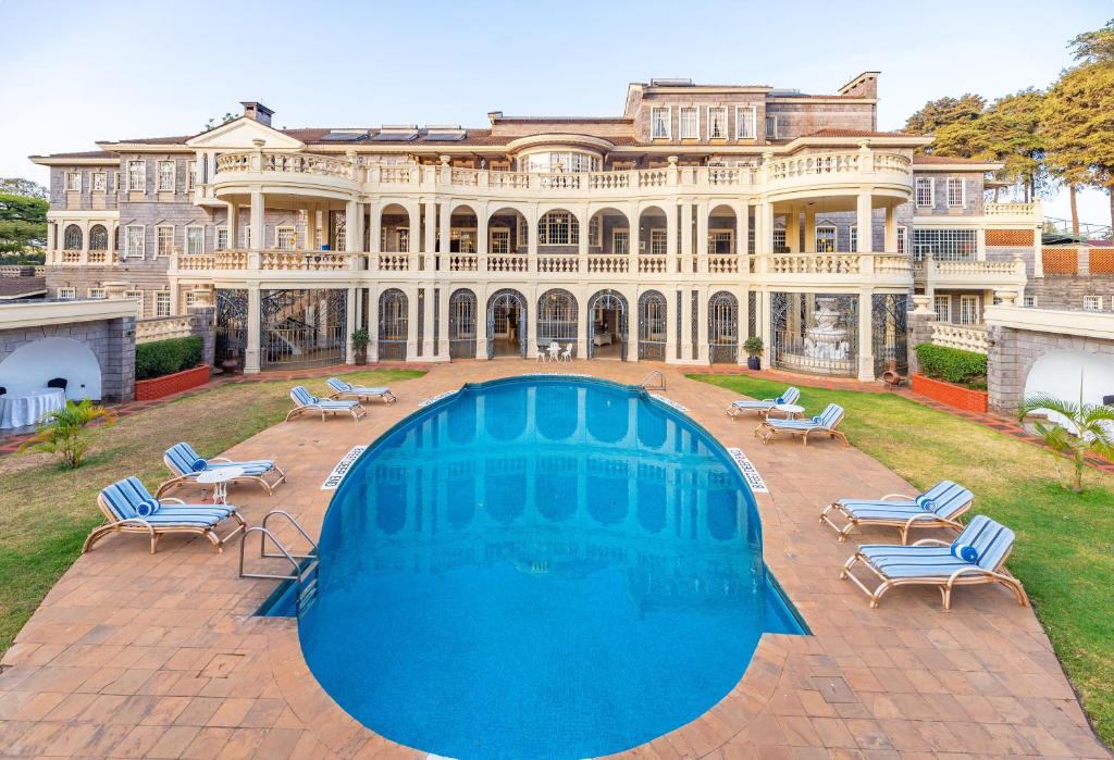 una gran mansión con una gran piscina frente a ella en Muthu Sovereign Suites & Spa, Limuru Road, Nairobi, en Limuru