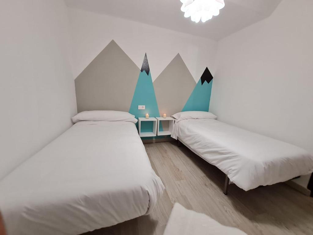 twee bedden in een kamer met bergen aan de muur bij Ribeira Sacra Apartament in Monforte de Lemos
