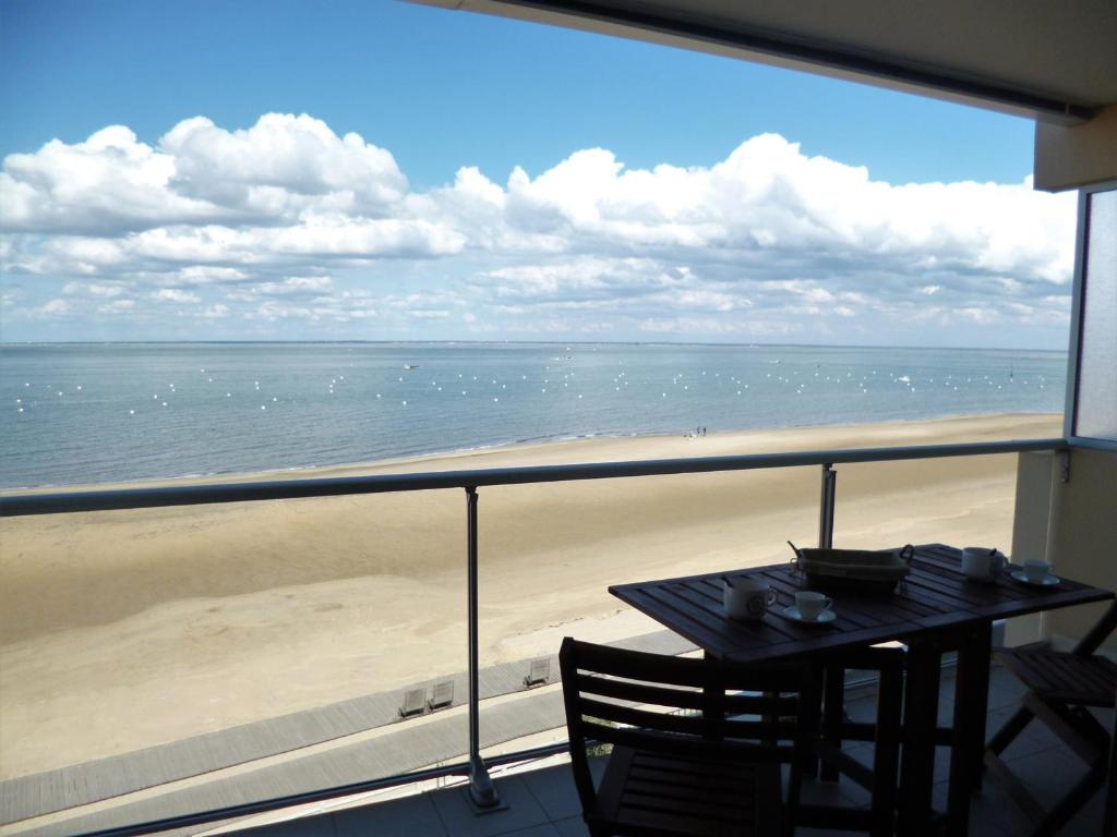 d'un balcon avec une table et une vue sur la plage. dans l'établissement Arcachon - Studio rénové avec grande terrasse, accès direct plage, parking - FR-1-420-11, à Arcachon