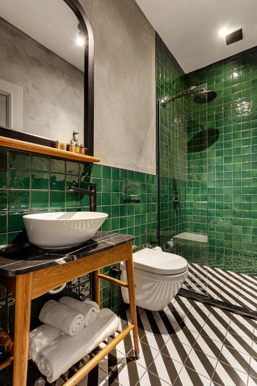 a green tiled bathroom with a sink and a toilet at World House Boutique Hotel Galata in Istanbul